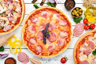 Beyaz ahşap masadaki pizza arka planı. Üst Manzara. Metnin için boş yer. Kırsal biçim.