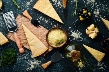 Siyah taşlı arka planda peynir bıçaklı sert peynirler. Parmesan peyniri. Üst Manzara. Metnin için boş yer.
