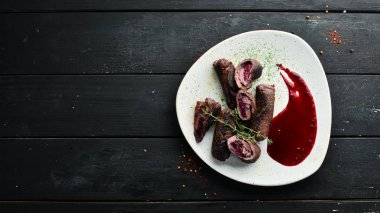 Kirazlı ve soslu dana eti ruloları. Üst görünüm, metin için boş alan. Kırsal biçim.