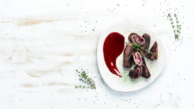 Kirazlı ve soslu dana eti ruloları. Üst görünüm, metin için boş alan. Kırsal biçim.