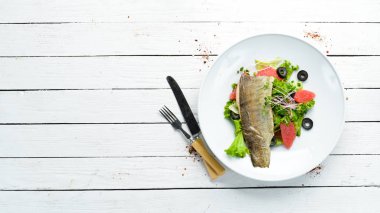 Bir tabakta greyfurt sebze salatası ve alabalık filetosu. Üst Manzara. Metnin için boş yer. Kırsal biçim.