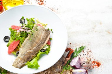 Bir tabakta greyfurt sebze salatası ve alabalık filetosu. Üst Manzara. Metnin için boş yer. Kırsal biçim.