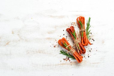 Beyaz arka planda biberiyeli kurutulmuş sosis. Kabanosy. Üst Manzara. Metnin için boş yer.