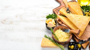 Beyaz ahşap arka planda sert peynir çeşitleri. Parmesan peyniri. Üst Manzara. Metnin için boş yer.