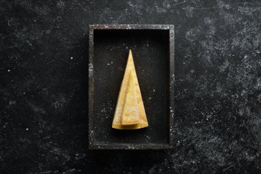 Piece of hard cheese on a white wooden background. Parmesan. Top view. Free space for your text. clipart