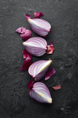 Siyah taş zemin üzerinde dilimlenmiş mor tatlı soğan. Üst Manzara. Metnin için boş yer. Kırsal biçim.