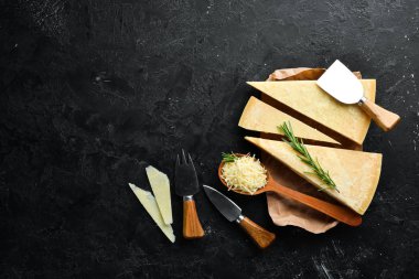 Parmesan peyniri. Siyah taş arka planda parmesan peyniri parçaları. Üst Manzara. Metnin için boş yer.
