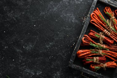 Siyah taşlı arka planda kurumuş sosis. Kabanosy. Üst Manzara. Metnin için boş yer.