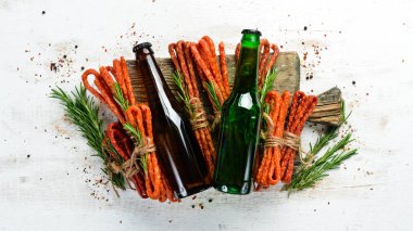 Şişede bira ve beyaz ahşap arka planda füme sosis. Bira, Kabanosy. Üst Manzara. Metnin için boş yer.