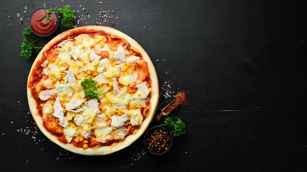 Traditional pizza with chicken, pineapple and corn. Top view. free space for your text. Rustic style.