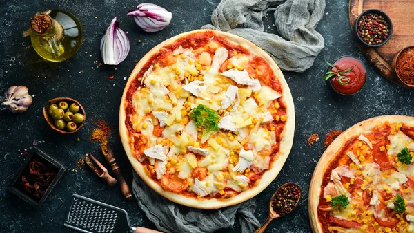 Traditional pizza with chicken, pineapple and corn. Top view. free space for your text. Rustic style.