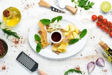 Çeşit çeşit peynirler. Tabakta dilimlenmiş peynir. Üst Manzara. Metnin için boş yer. Kırsal biçim.