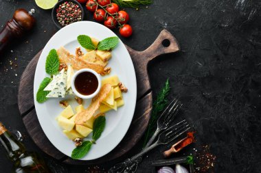 Çeşit çeşit peynirler. Tabakta dilimlenmiş peynir. Üst Manzara. Metnin için boş yer. Kırsal biçim.