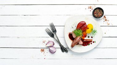 Armut ve kızılcık soslu fırında ördek filetosu. Üst Manzara. Metnin için boş yer. Kırsal biçim.