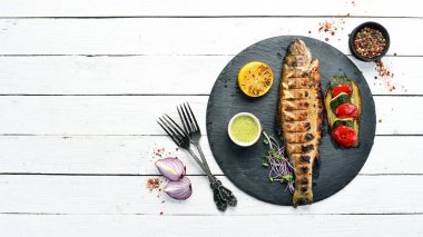 Siyah tabakta sebzeli ızgara alabalık. Üst Manzara. Metnin için boş yer. Kırsal biçim.