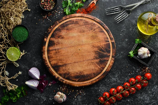 Food banner. Spices, vegetables and herbs on a black stone background. Top view. free space for your text. Rustic style.