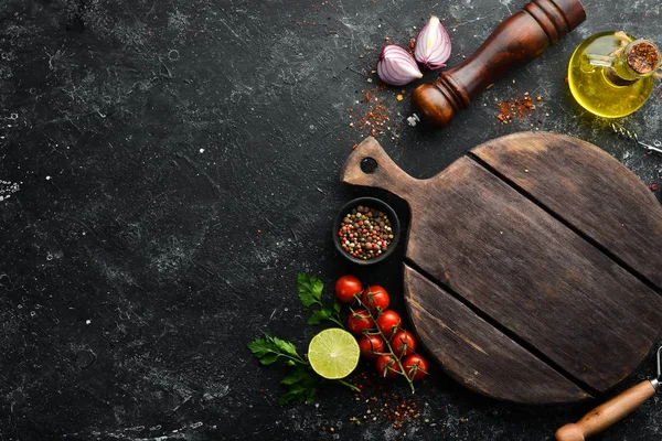 Food banner. Spices, vegetables and herbs on a black stone background. Top view. free space for your text. Rustic style.