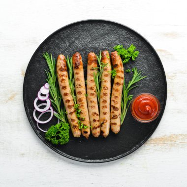 Siyah taş tabakta domates soslu ızgara sosisler. Barbekü. Üst görünüm. Ücretsiz kopyalama alanı.