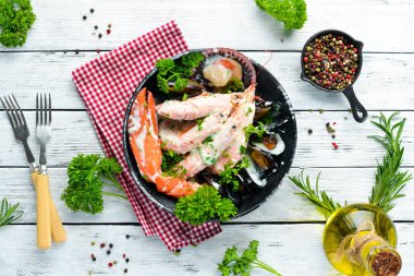 Siyah taş tabaktabaktabaktabaktabaktabaktabaktabaktabakta kremalı soslu haşlanmış deniz ürünleri. Deniz ürünleri, karides, kabuklu deniz ürünleri, ıstakoz. Üst te. Ücretsiz kopyalama alanı.