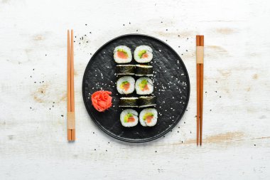 Somon, avokado ve nori ile suşi maki. Metnin için boş yer. Geleneksel Japon Mutfağı. Üst Manzara. Kırsal biçim.