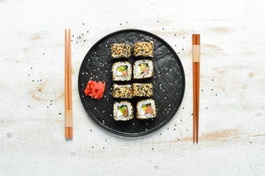 Susamlı suşi, Philadelphia peyniri, somon, avokado. Geleneksel Japon Mutfağı. Üst Manzara. Kırsal biçim.