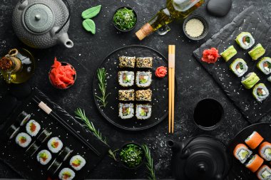 Suşi rulolarının arka planında çay, zencefil, wasabi ve soya sosu var. Japon Geleneksel Mutfağı.