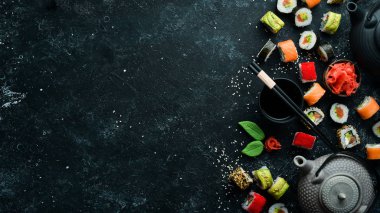 Suşi rulolarının arka planında çay, zencefil, wasabi ve soya sosu var. Japon Geleneksel Mutfağı.