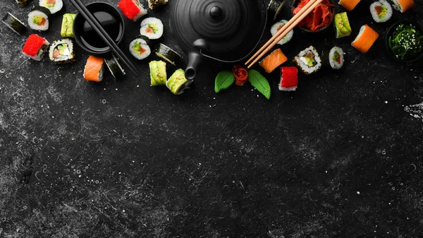 背景寿司卷与茶 芥末和酱油在黑石背景 日本传统烹饪 — 图库照片