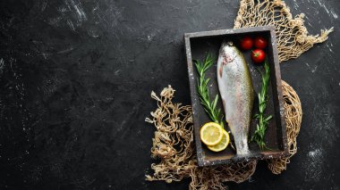 Siyah taş arka planda sebze ile çiğ balık alabalık. Üst te. Metniniz için boş alan.