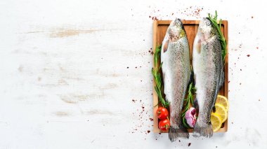 Beyaz ahşap arka planda sebze li çiğ balık. Balık alabalığı. Üst te. Metniniz için boş alan.