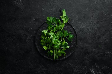 Siyah taş arka planda taze yeşil maydanoz. Sebzeler. Üst Manzara. Metnin için boş yer.