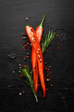 Siyah ahşap arka planda taze kırmızı biber. Üst Manzara. Metnin için boş yer.