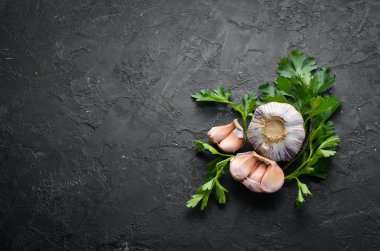 Koyu arkaplanda taze maydanoz ve sarımsak. Sebzeler. Üst Manzara. Metnin için boş yer.