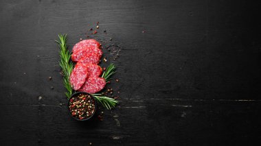 Traditional smoked salami sausage with spices. Slice sausages. Rosemary. Top view. Free space for your text.