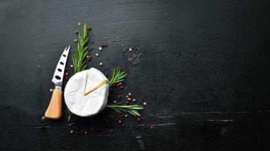 Camembert cheese on black background. Top view. Free space for your text.
