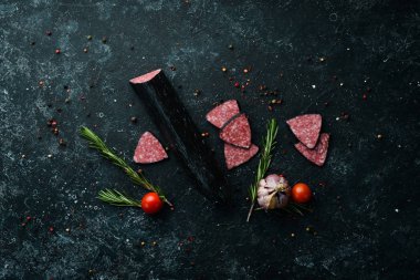 Salami sausage with spices. Slice sausages. Rosemary. Top view. Free space for your text.