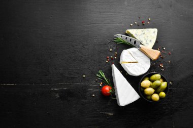 Brie cheese and blue cheese with mold on black background. Top view. Free space for your text.