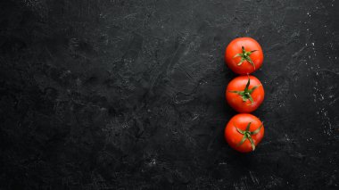 Fresh red tomatoes on a dark background. Vegetables. Top view. Free space for your text.