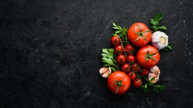 Fresh red tomatoes on a dark background. Vegetables. Top view. Free space for your text.