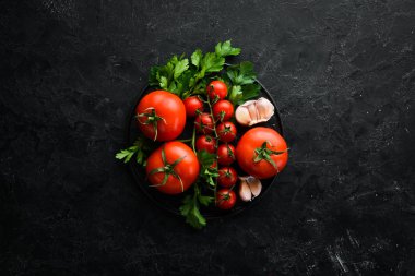 Fresh red tomatoes on a dark background. Vegetables. Top view. Free space for your text.