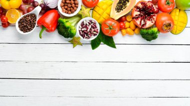 Vegetables, fruits, beans and nuts on a white background. Background Organic food. Top view. Free space for your text.