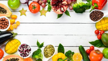 Vegetables, fruits, beans and nuts on a white background. Background Organic food. Top view. Free space for your text.