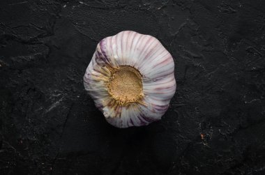 Fresh garlic on a dark background. Vegetables. Top view. Free space for your text.