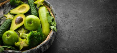 Meyve ve sebzeler siyah taş bir arka planda bir kutuda. Tropik meyveler. Üst Manzara. Metnin için boş yer.