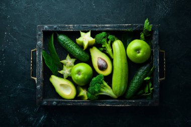 Meyve ve sebzeler siyah taş bir arka planda bir kutuda. Tropik meyveler. Üst Manzara. Metnin için boş yer.