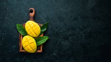 Mavi ahşap arka planda mango meyvesi. Tropik meyveler. Üst Manzara. Metnin için boş yer.