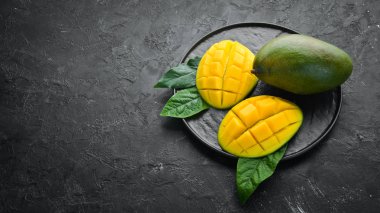 Mavi ahşap arka planda mango meyvesi. Tropik meyveler. Üst Manzara. Metnin için boş yer.