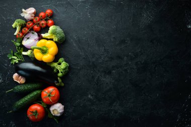 Tahta kutuda taze sebzeler, siyah taş arka planda. Tropik meyveler. Üst Manzara. Metnin için boş yer.