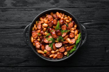 Siyah tabakta domates soslu fasulye. Üst Manzara. Metnin için boş yer.