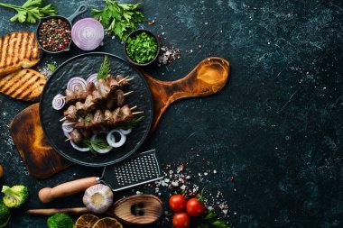 Siyah bir tabakta pişmiş tavuk kalbi. Tavuk eti. Üst Manzara. Metnin için boş yer.